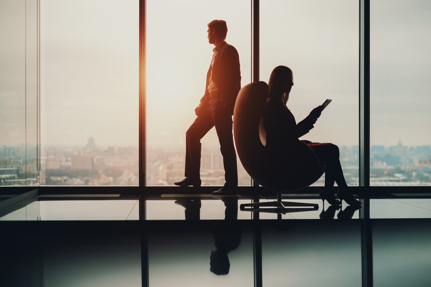 Boss and secretary near window in luxury office interior